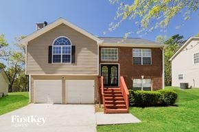 Douglasville house for rent - a brown house with a white garage door