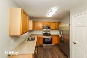 Douglasville house for rent - an empty kitchen with wooden cabinets and stainless steel appliances