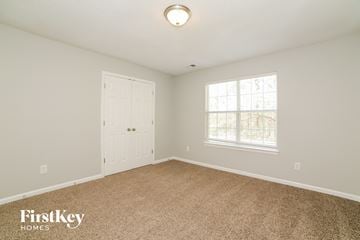 Douglasville house for rent - a bedroom with carpet and a door and a window