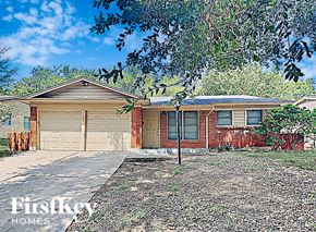Fort Worth house for rent - a brick house with two garage doors and a tree