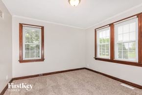 Florissant house for rent - a bedroom with two windows and a carpeted floor