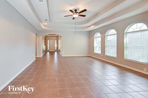 Spring house for rent - A spacious room with a ceiling fan and tiled flooring.