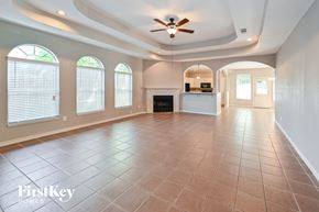Spring house for rent - A spacious room with a fireplace and a ceiling fan.