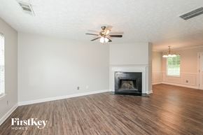 Ellenwood house for rent - a living room with a fireplace and a ceiling fan