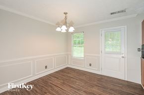 Ellenwood house for rent - a dining room with a wood floor and white walls