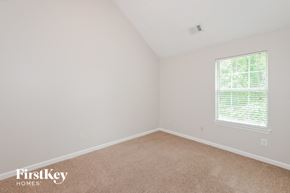 Ellenwood house for rent - a bedroom with a carpeted floor and a window