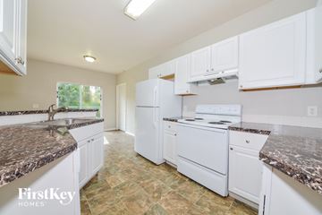 North Port house for rent - a kitchen with white appliances and granite counter tops