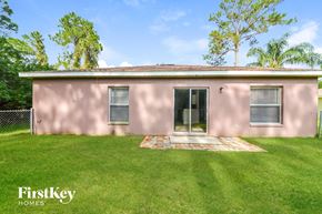 North Port house for rent - a pink house with a grass yard and a backdoor