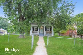 Kansas City house for rent - A house with a porch and a fence in front of it.