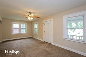 Kansas City house for rent - A room with a carpet floor, a ceiling fan, and a door.