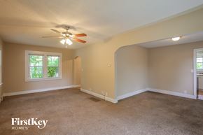 Kansas City house for rent - A spacious room with a carpeted floor and a ceiling fan.