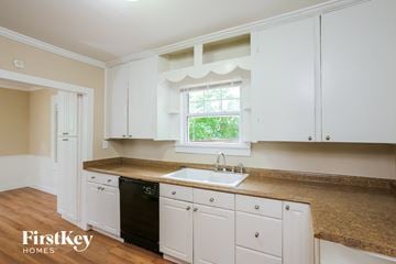 Kansas City house for rent - A kitchen with white cabinets and a black dishwasher.
