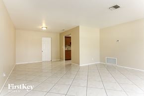 Lauderhill house for rent - A spacious empty room with a doorway leading to another room.