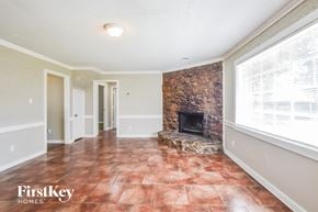 Memphis house for rent - A room with a stone fireplace and tile flooring.