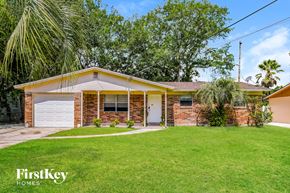 Jacksonville house for rent - a small brick house with a lawn and a garage