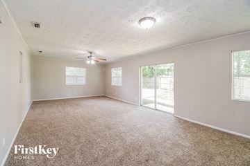 Jacksonville house for rent - a spacious living room with carpet and a ceiling fan