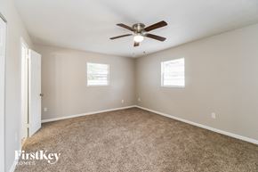Jacksonville house for rent - a bedroom with carpet and a ceiling fan