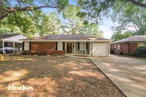 Memphis house for rent - a small brick house with a driveway and a tree
