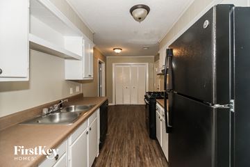 Memphis house for rent - a kitchen with a black refrigerator and a sink