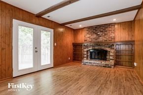 Kansas City house for rent - A room with wooden walls and a brick fireplace.