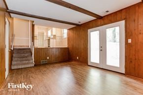 Kansas City house for rent - A wooden room with a staircase and a door.