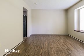 Blue Springs house for rent - the living room of an apartment with wood flooring and white walls