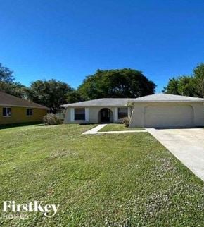 Cape Coral house for rent - A white house with a yellow house in the background and a clear blue sky.