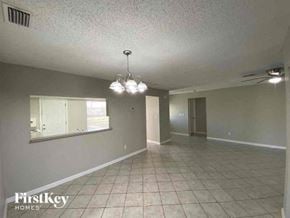 Cape Coral house for rent - A spacious room with a chandelier and tiled flooring.
