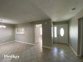 Cape Coral house for rent - A spacious room with tile flooring and a chandelier.