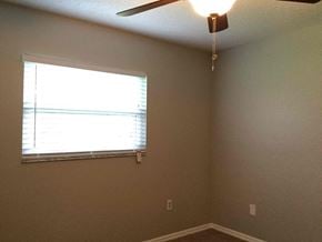Lakeland house for rent - a bedroom with a ceiling fan and a window
