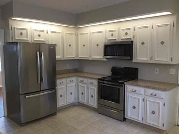 Lakeland house for rent - a kitchen with white cabinets and stainless steel appliances