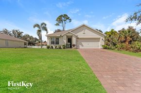 North Port house for rent - a house with a driveway and a lawn in front of it