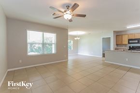 North Port house for rent - an empty kitchen and living room with a ceiling fan