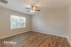North Port house for rent - the spacious living room with hardwood floors and a ceiling fan