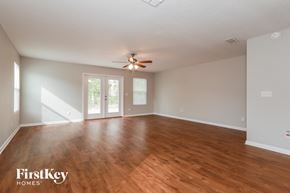 Jacksonville house for rent - an empty living room with wood floors and a ceiling fan