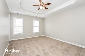 Acworth house for rent - a living room with carpet and a ceiling fan