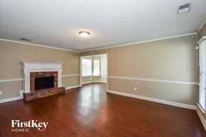 Memphis house for rent - A spacious room with a fireplace and wooden floors.