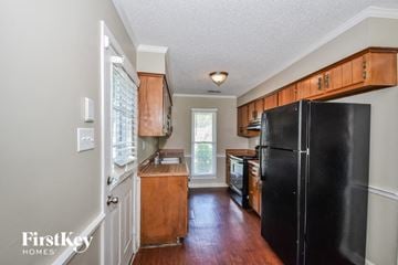 Memphis house for rent - A kitchen with wooden cabinets and a black refrigerator.