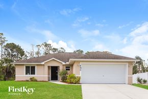 North Port house for rent - A house with a garage door and a driveway in front of it.