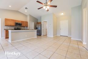 North Port house for rent - A spacious kitchen and living room with a ceiling fan and tiled flooring.