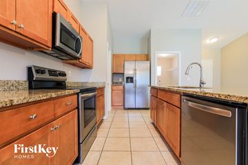 North Port house for rent - A kitchen with wooden cabinets and a stainless steel refrigerator.