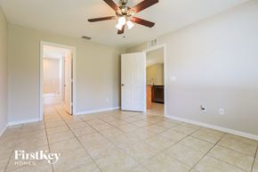 North Port house for rent - A spacious room with a ceiling fan and tile flooring.