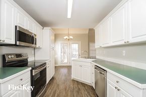 Pfafftown house for rent - a kitchen with white cabinets and a green counter top