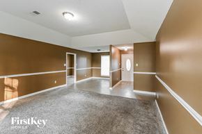 Memphis house for rent - a empty living room with brown walls and white carpet