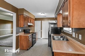 Memphis house for rent - a kitchen with black appliances and wooden cabinets