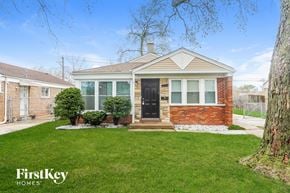 Chicago house for rent - the front of a brick house with a lawn and a black door