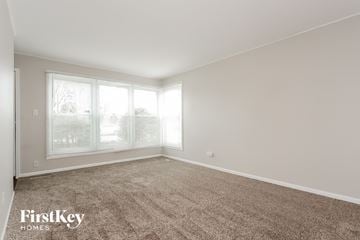 Chicago house for rent - a spacious living room with carpet and large windows