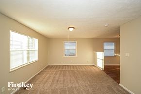 Indianapolis house for rent - A spacious room with a carpeted floor and two windows.