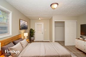 Indianapolis house for rent - A bedroom with a bed, dresser, and a painting on the wall.