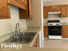 Rowlett house for rent - A kitchen with a sink and a stove top oven.